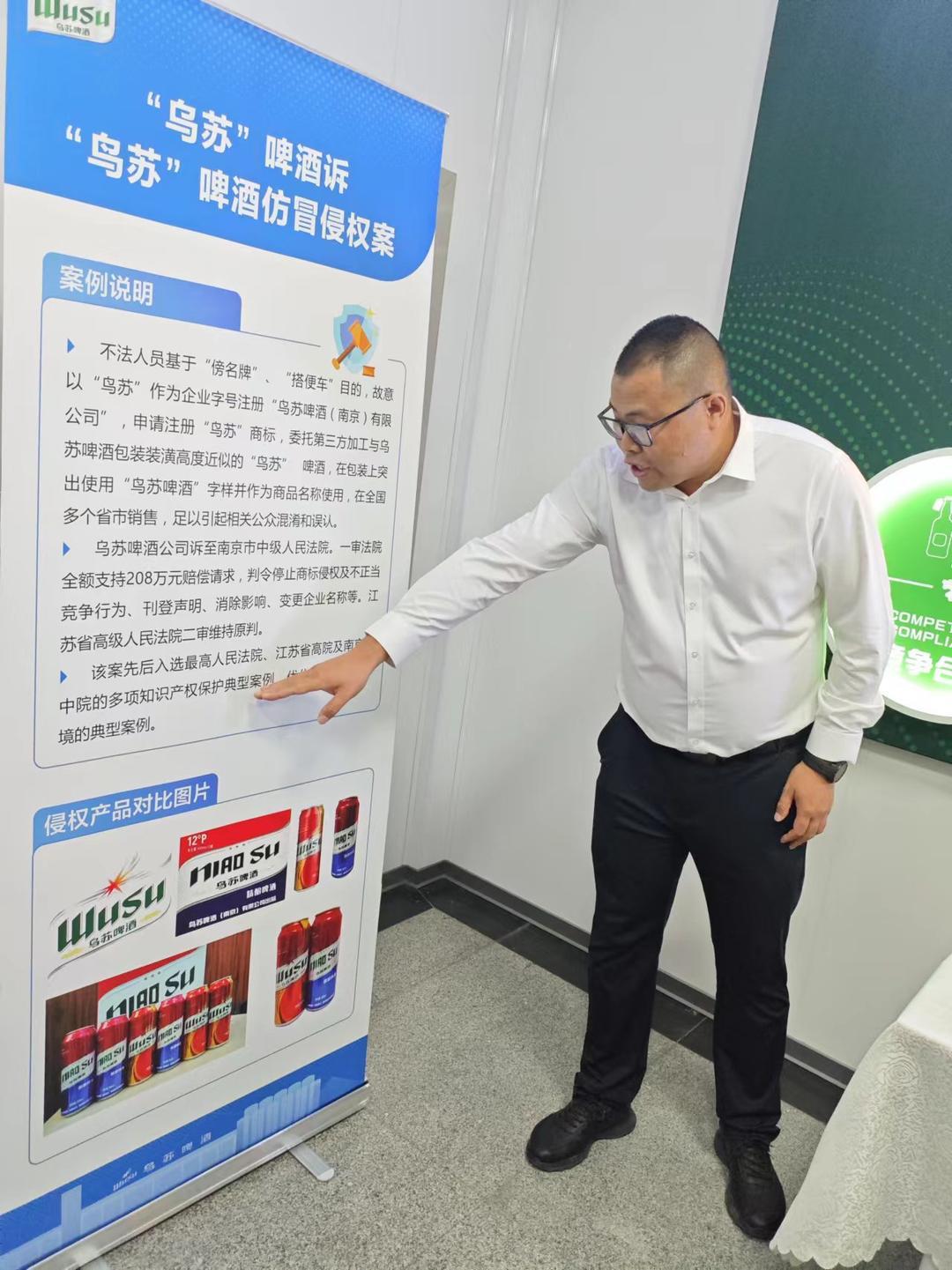 ▲刘斌向记者介绍乌苏啤酒遭遇的仿冒侵权案件