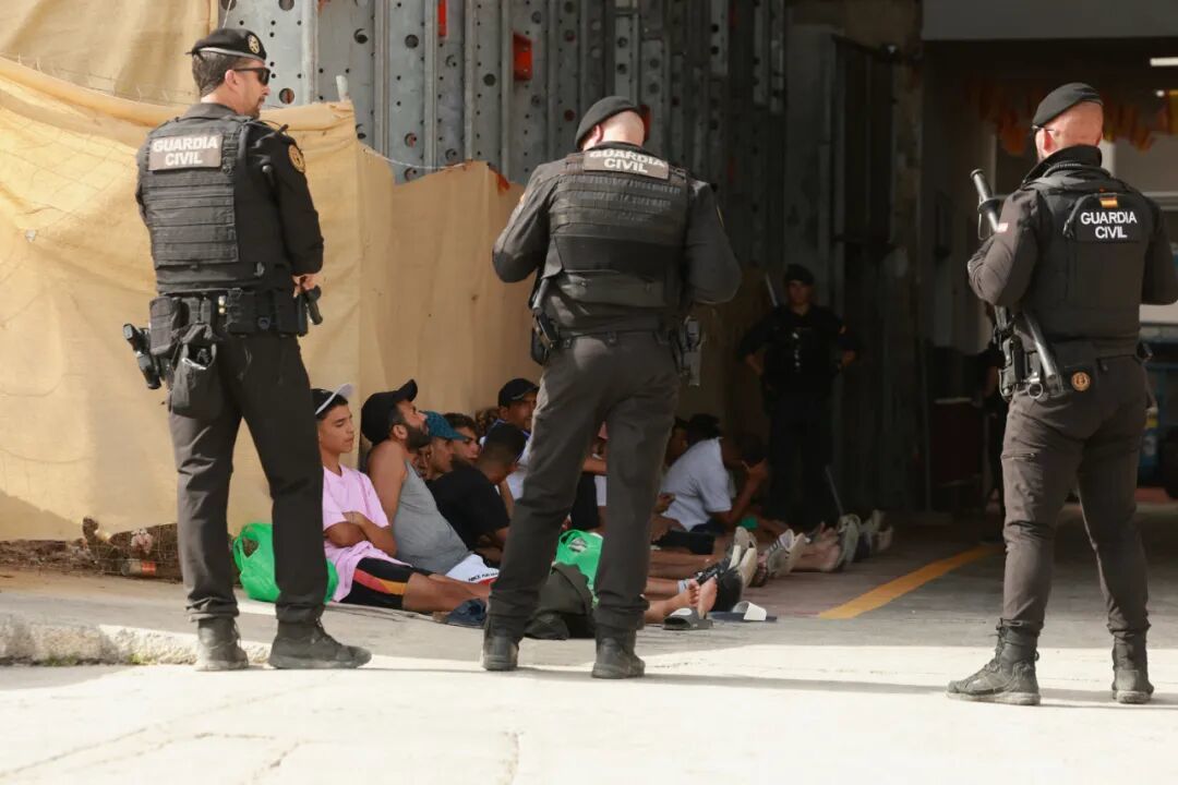 8月1日,在西班牙飞地休达,西班牙国民警卫队成员看守从摩洛哥入境的非法移民 / 图源:新华社